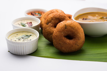 south indian food called vada sambar or sambar vada or wada, served with coconut, green and red...