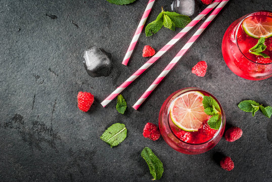 Summer refreshing non-alcoholic cocktails. Fruit drinks. Raspberry mojito lemonade with fresh organic mint and lime. On a black stone table. Copy space top view