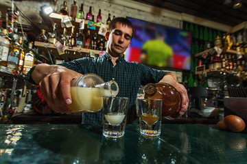 The bartender fills the glasses