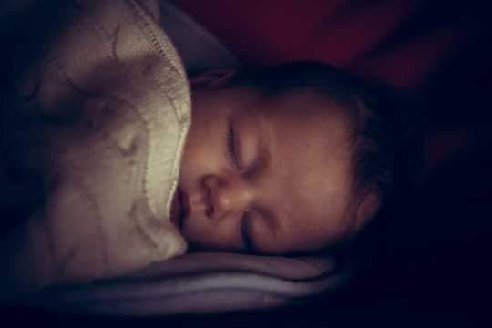 Newborn Baby Peaceful Sleeping In Dark Room With Low Natural Light Covered With Comfortable Blanket Symbolize Peace And Tranquility