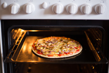 Pizza baking in the oven (close)