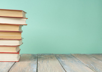 Stack of colorful books on wooden desk. Copy space for text. Back to school. Education background