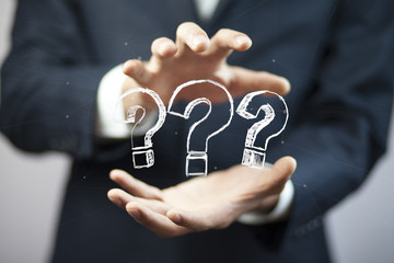 Question marks in businessman  hand in screen