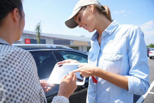 Woman In Parking Lot Renting Car From Rental Company