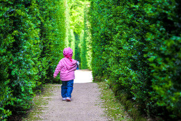 baby girl left alone newborn walk child alone among the hedges of the garden