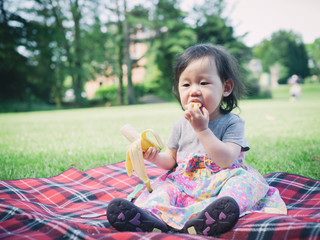 baby girl has a picnic in summer garden