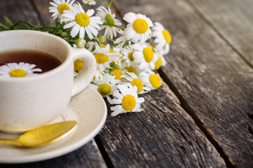 Fototapeta na wymiar cup of herbal chamomile tea with camomile dry blossoms, dried camomile flowers. doctor treatment and prevention of immune concept, medicine - folk, alternative, complementary, traditional medicine 
