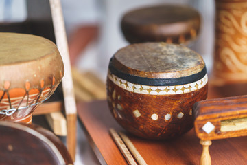 Old leather drum and drumsticks - membrane musical instrument. Ancient ethnic music on a folk...
