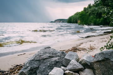 Natural lake with forest in the background and stormy clouds on the sky