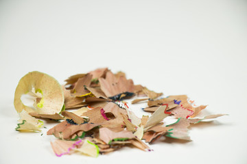 Closeup of colourful crayon sharpenings on white background.