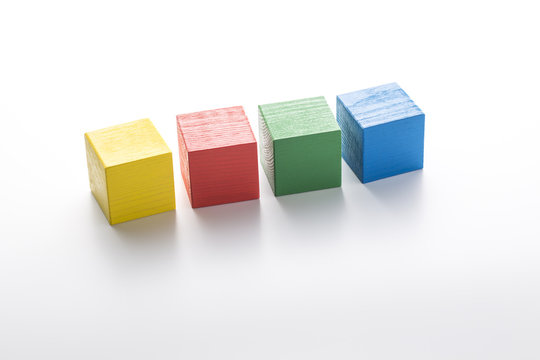 Yellow, red, green and blue wooden cubes isolated on white background.