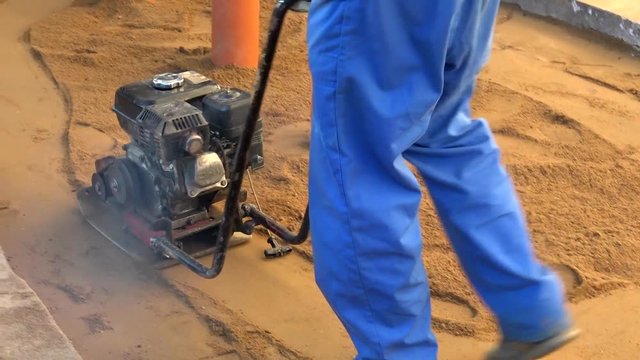 Ramming mechanism for sand. Manual compaction of earth work. The construction machine.