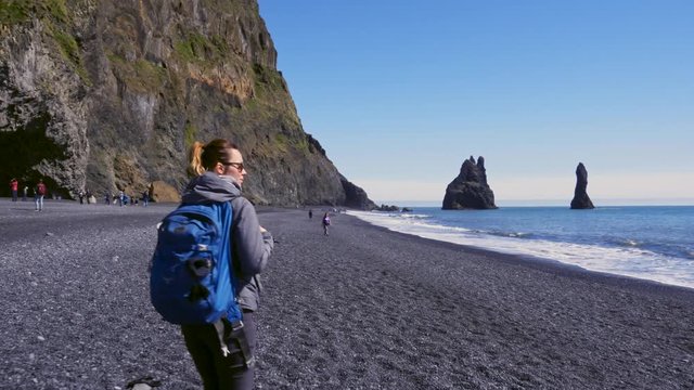 Woman exploring beautiful Reynisfjara beach near Vik, Icealnd