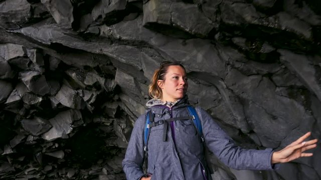 Woman exploring cave on Reynisfjara beach near Vik, Icealnd