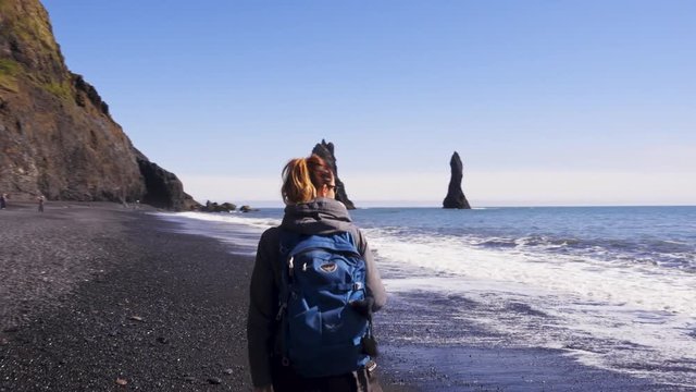Woman exploring beautiful Reynisfjara beach near Vik, Icealnd