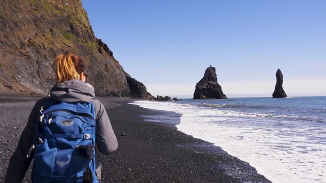 Woman exploring beautiful Reynisfjara beach near Vik, Icealnd