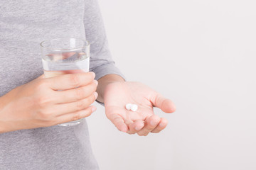 Woman's hand with medicine and glass