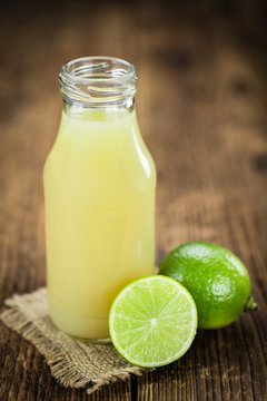 Portion of Fresh Lime Juice on wooden background (selective focus)