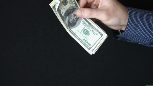 Taking Money Out of a wallet. The man opens a leather wallet and pulls out a 100 dollar bills. slow motion
