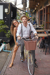 Young cople with cycle at the town street