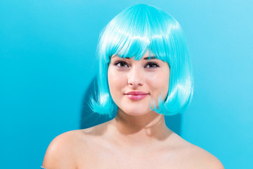 Beautiful woman in a bright blue wig on a blue background