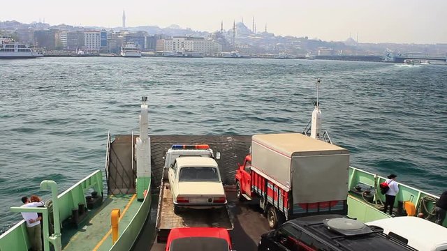 City car ferry boat heading up towards old Istanbul. A ro-ro ship carrying a lorry and flat-bed tow truck loaded up the car onto its carrier, sailing into the harbor 