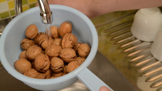 Wash the nuts in the colander in the kitchen.