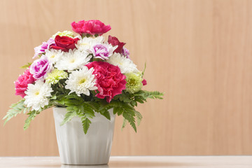 Bouquet Flowers in Vase on Table Wooden background.