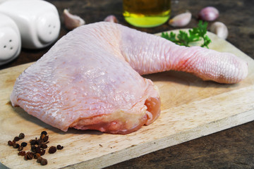Fresh raw chicken legs arrangement on kitchen cutting board