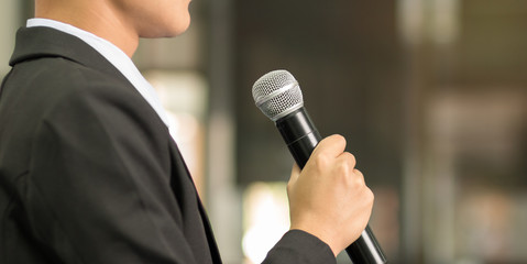 Asian smart businessman speech, talking with microphone in seminar conference meeting hall
