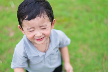 Little Asian kid at the playground under the sunlight, shallow DOF