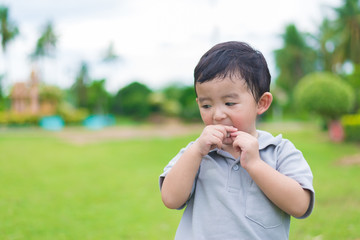 Fototapeta premium Little Asian kid at the playground under the sunlight, shallow DOF