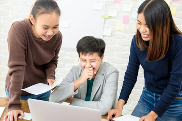 College students having fun, looking at laptop coomputer