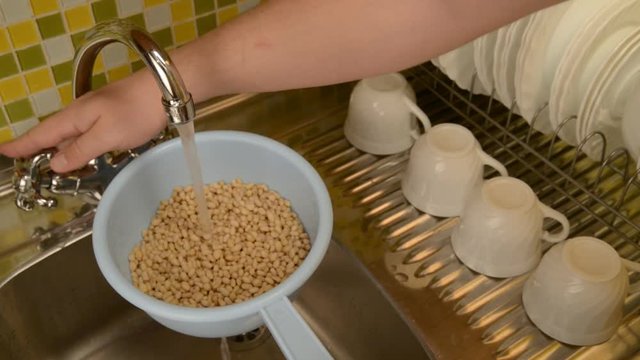 Wash the nuts in the colander in the kitchen.