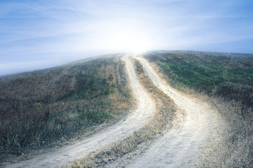 Conceptual countryside landscape with magic light at the end of the road.