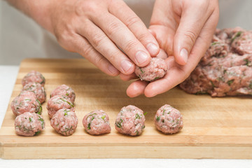 Chef's hands creating meatballs for soup in the kitchen. Preparation for cooking. Healthy eating...
