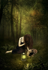 A sad girl in a night forest in the light of a lamp. Broken dreams