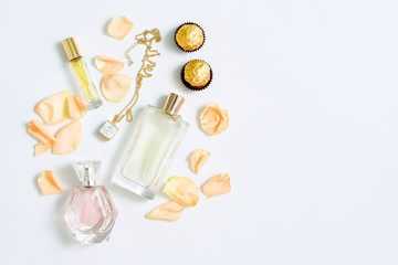 Perfume bottles with flowers petals on white background. Perfumery, cosmetics, jewelry and fragrance collection. Stylized feminine flatlay. Women accessories top view, space for text.