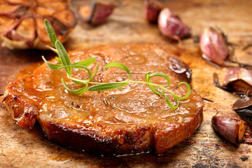 Fried grilled pork neck with garlic on rustic background