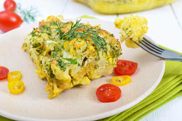 Cauliflower baked with cheese, greens and egg. A large piece on a plate. Proper nutrition. Dietary menu. Vegetarian cuisine.