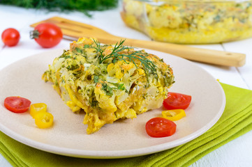 Cauliflower baked with cheese, greens and egg. A large piece on a plate. Proper nutrition. Dietary menu. Vegetarian cuisine.