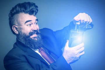 Adult bearded man in suit pulling out the cork from a luminous bottle with alcohol