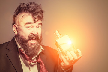 Adult bearded man in suit holding a glowing bottle of alcohol