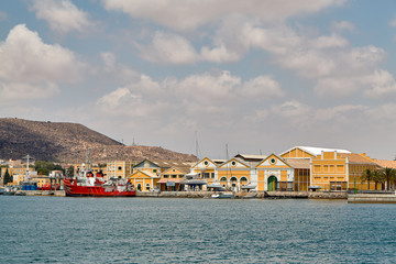 Fototapeta na wymiar The military area with yellow buildings, in which the entrance is closed. Located in an open area near the port. Cartagena, Spain.