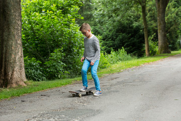 Fototapeta premium Jugendlicher / Kind / Heranwachsender spielt mit Skateboard / Fährt Skateboard