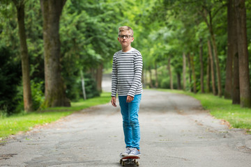 Jugendlicher / Kind / Heranwachsender spielt mit Skateboard / Fährt Skateboard