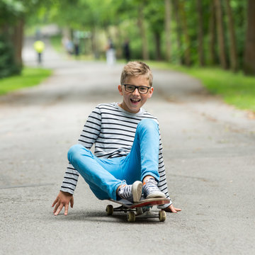Jugendlicher / Kind / Heranwachsender spielt mit Skateboard / Fährt Skateboard