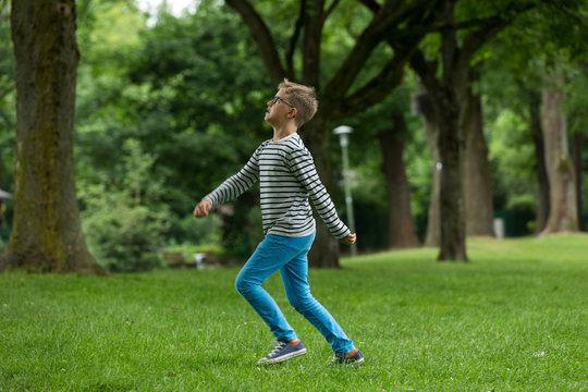 Jugendlicher / Heranwachsender / Junge / Kind spielt mit Fussball auf gr&uuml;ner Wiese / Wald