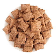 Chocolate pads corn flakes in white bowl isolated, top view. Cereals.