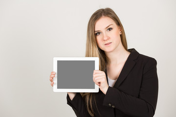 Junge Frau / Business Outfit hält weiße Fläche mit Platz für Text Querformat